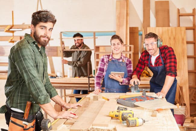 Junge Handwerker in der Schreiner Lehre zusammen an der Werkbank der Schreinerei